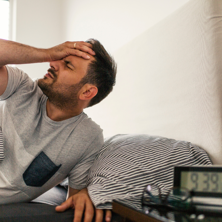 Man with migraine in bed.