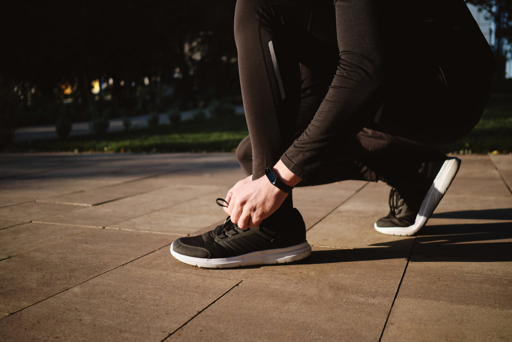 man running with a fitness tracker.